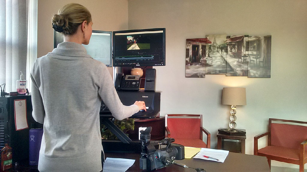 Jaime on a shoot with clapperboard and tripod